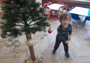 Dziecko zawiesza ozdobę na choince