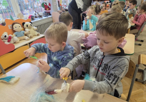 dzieci tworzą aniołki z sizalu