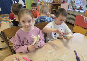 dzieci tworzą aniołki z sizalu