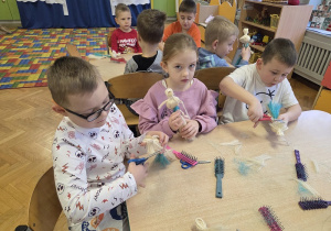 dzieci tworzą aniołki z sizalu