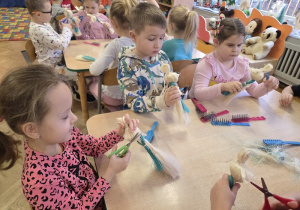 dzieci tworzą aniołki z sizalu