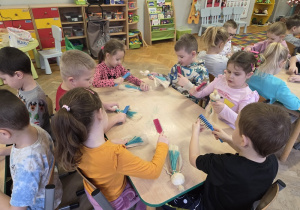 dzieci tworzą aniołki z sizalu