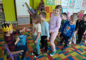 Chłopiec częstuje dzieci cukierkami