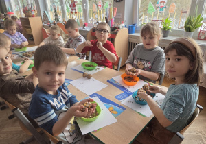 dzieci obtaczają kule w nasionach
