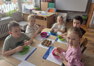 dzieci obtaczają kule w nasionach