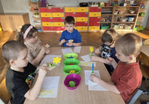 dzieci malują drewniane kwiaty