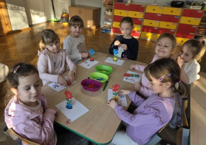 dzieci malują drewniane kwiaty