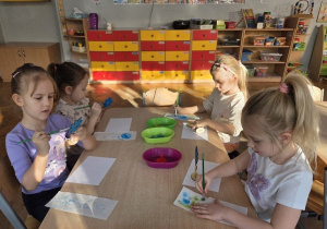 dzieci malują drewniane kwiaty