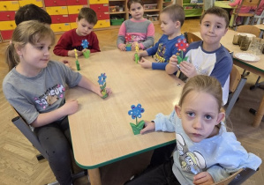dzieci ozdabiają drewniane kwiaty