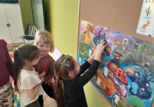 Dziewczynka przykleja sylwetę kolejnej emocji na plakat projektowy