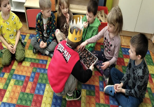 chłopiec częstuje czekoladkami