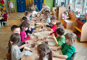 Dzieci jedzą podwieczorek w formie szwedzkiego stołu