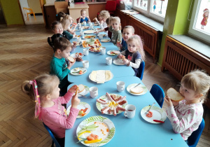 Dzieci jedzą podwieczorek w formie szwedzkiego stołu