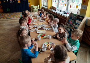 Dzieci jedzą podwieczorek w formie szwedzkiego stołu