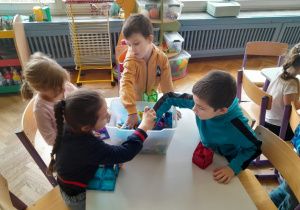 Dzieci budują z klocków kolorowe domki