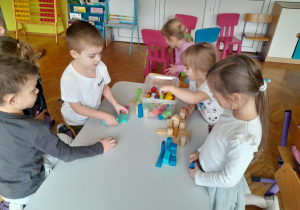 Dzieci budują z klocków kolorowe domki