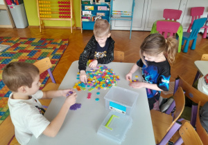 Dzieci budują z klocków kolorowe domki