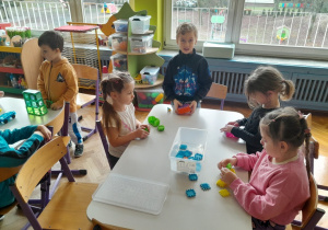 Dzieci budują z klocków kolorowe domki