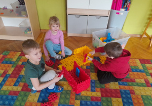 Dzieci budują z klocków kolorowe domki