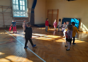 Dzieci podczas zabaw ruchowych na sali gimnastycznej