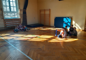 Dzieci podczas zabaw ruchowych na sali gimnastycznej