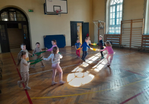 Dzieci podczas zabaw ruchowych na sali gimnastycznej