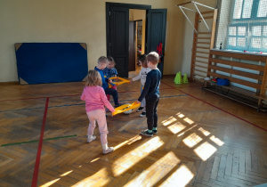 Dzieci podczas zabaw ruchowych na sali gimnastycznej