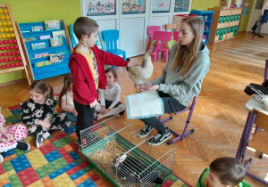 Dziecko głaszcze kurę