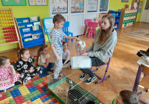 Dziecko głaszcze kurę