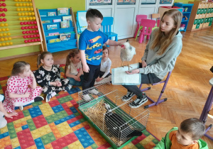 Dziecko głaszcze kurę