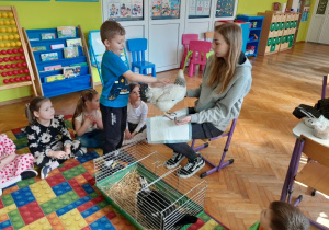 Dziecko głaszcze kurę