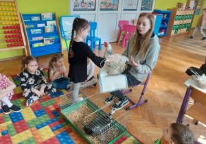 Dziecko głaszcze kurę