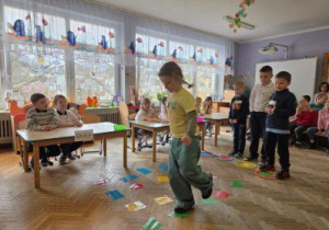 Dzieci rozwiązują zadanie matematyczne z figurami geometrycznymi