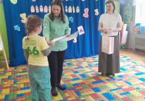 Dzieci otrzymują dyplomy i nagrody za udział w konkursie