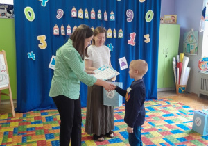 Dzieci otrzymują dyplomy i nagrody za udział w konkursie