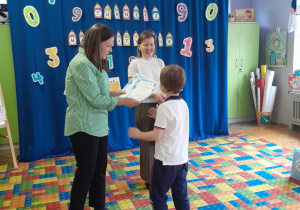 Dzieci otrzymują dyplomy i nagrody za udział w konkursie