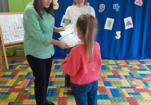 Dzieci otrzymują dyplomy i nagrody za udział w konkursie