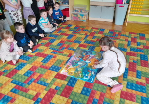 Dziewczynka przykleja sylwetę na plakat projektowy