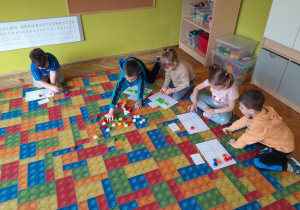 Dzieci układają nakrętki na planszy