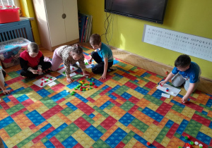 Dzieci układają nakrętki na planszy