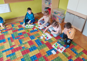 Dzieci układają nakrętki na planszy