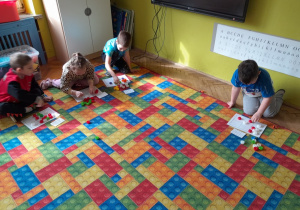 Dzieci układają nakrętki na planszy