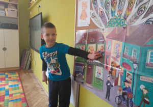 Dziecko pokazuje na planszy postacie z wiersza