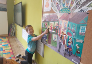 Dziecko pokazuje na planszy postacie z wiersza