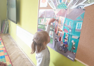 Dziecko pokazuje na planszy postacie z wiersza