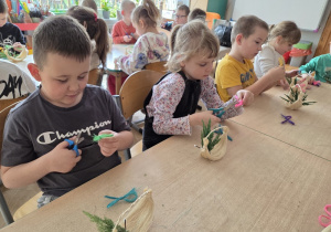 dzieci tworzą koszyczki z sizalu