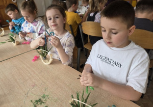 dzieci tworzą koszyczki z sizalu