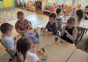 dzieci tworzą koszyczki z sizalu