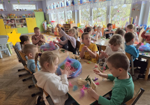 dzieci tworzą koszyczki z sizalu