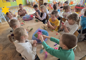 dzieci tworzą koszyczki z sizalu